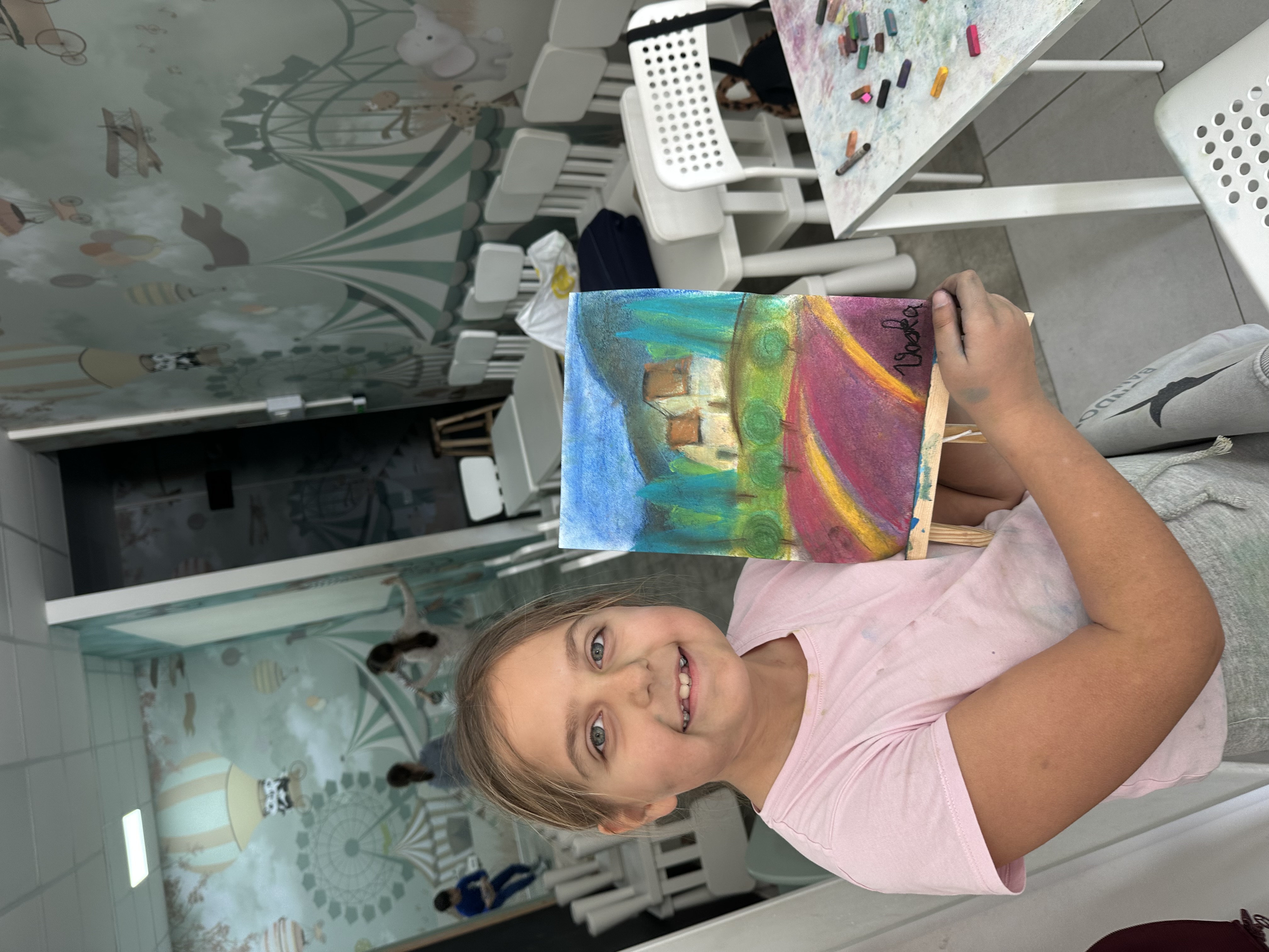 Student with pastel landscape on a small easel